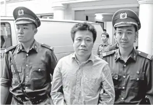  ??  ?? THAM (tengah) diiringi anggota polis selepas dijatuhkan hukuman penjara seumur hidup di mahkamah Hanoi, Vietnam semalam. — Gambar Reuters