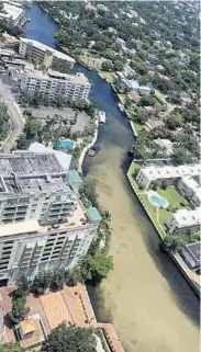  ?? JASON HOLLOWAY/COURTESY ?? Discolored water winds its way along the New River toward the Intracoast­al Waterway on Tuesday afternoon. The building on the left opposite the swimming pool is the Riverside Hotel.