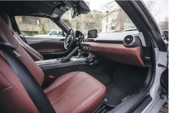  ?? DARREN STONE PHOTOS, TIMES COLONIST ?? The interior of the MX-5 is cosy, but there’s little room to spare. Even the glovebox has been moved to between the two seats to maximize legroom.