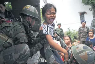  ?? AFP ?? Indian army personnel help a girl at a temporary shelter in the northeaste­rn Indian state of Manipur on May 10.