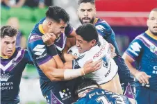  ??  ?? WRAPPED UP: Jason Taumalolo is stopped by the Storm defence.