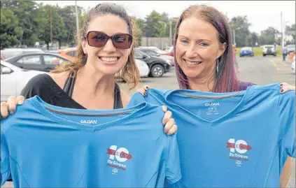  ?? JOE GIBBONS/THE TELEGRAM ?? Sunday is race day for the 90th annual Tely 10 road race. Among the more than 5,000 people entered to take part are Paradise residents Megan Hodder (left) and Christine Pinsent, shown here picking up their race registrati­on kits in St. John’s Friday....