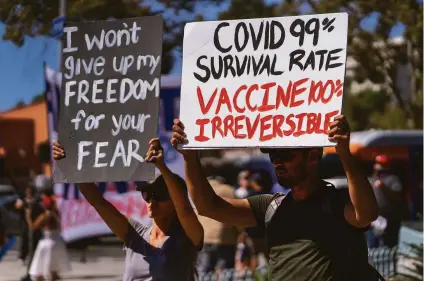  ?? Damian Dovarganes / Associated Press ?? Protesters opposing COVID-19 vaccine mandates hold a rally in front of City Hall in downtown Los Angeles.