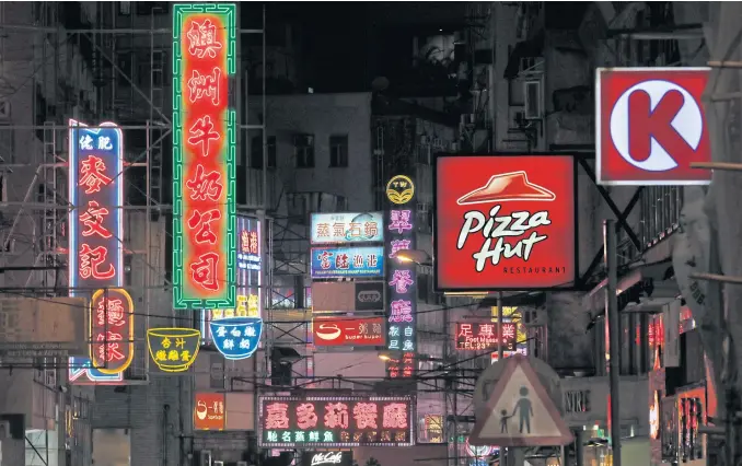  ?? PHOTOS BY AP ?? Neon signs, two at left, mixing with other LED signs are seen at a downtown street in Hong Kong.