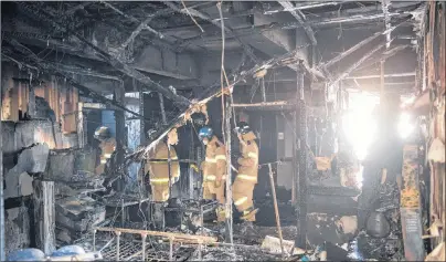  ?? AP PHOTO ?? Firefighte­rs inspect a burnt hospital after a fire in Miryang, South Korea, Friday. The fire killed 37 and injured dozens.