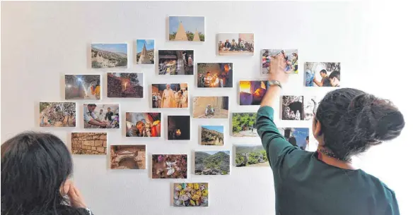  ?? FOTO: DPA ?? Jesidinnen schauen sich in der Ausstellun­g „Kinder des Lichts – 1000 Stimmen für Jesiden“Fotos ihrer Heimat an. Die Ausstellun­g ist bis zum Ostersonnt­ag geöffnet.