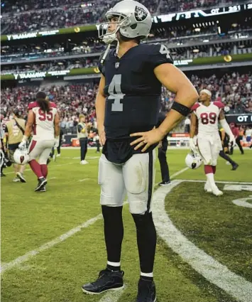  ?? JOHN LOCHER/AP ?? Raiders QB Derek Carr stands on the field after an overtime loss to the Cardinals on Sept. 18 in Las Vegas.