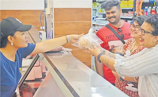  ?? Picture: ATASA WILLIAMS ?? A Fresh Choice staff member serves Sharon Bhagwan-Rolls and her family.