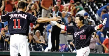  ?? MITCHELL LAYTON / GETTY IMAGES ?? Former Braves catcher Kurt Suzuki exults with teammates as his three-run home run in the ninth inning lifts the Nationals to a come-from-behind 11-10 victory over the Mets on Tuesday.