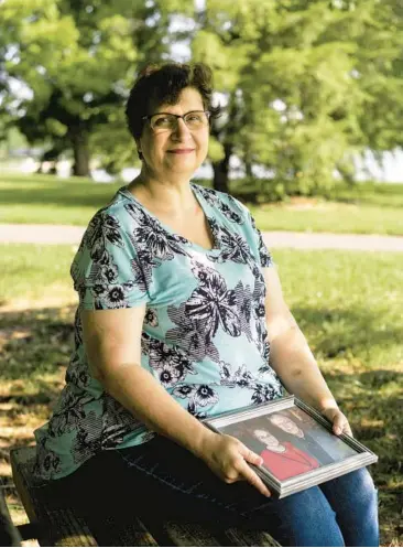  ?? NATOSHA VIA/THE NEW YORK TIMES ?? Dana Guthrie holds a portrait of her parents in Elizabetht­own, Ky. Many employees reduce their hours or stop working to help ailing family members, but it may be years before they fully return to the workforce.