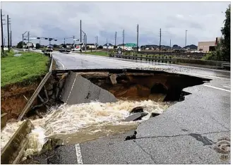  ?? ROSENBERG POLICE DEPARTMENT / AP ?? Water rushes from a large sinkhole on FM 762 in Rosenberg, near Houston, on Aug. 27, as then-Tropical Storm Harvey pounded the region. Texas officials are hoping the federal government will fund $61 billion in projects to bolster infrastruc­ture against...