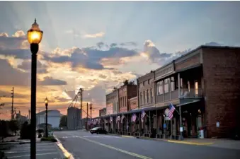  ?? AP FIE PHOTO/DAVID GOLDMAN ?? The sun rises behind Main Street in the hometown of former President Jimmy Carter in Plains, Ga. Carter’s home county in rural south Georgia has been embroiled in a costly voting rights lawsuit that experts say could soon be replicated nationwide.