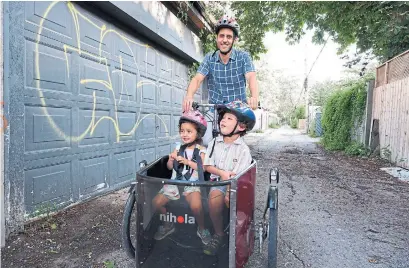  ?? ANDREA YU ?? Daniel Suss rides a three-wheeled Nihola cargo bike to drop his daughter, Lily, off at daycare and his son, Harvey, at school.