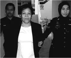  ?? - Bernama photo ?? Maria Elvira Pinto Exposto (left) is escorted from the Shah Alam High Court after she was cleared of drug traffickin­g charges in Shah Alam.