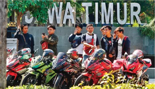  ?? AHMAD KHUSAINI/JAWA POS ?? SEPERTI TIDAK ADA COVID-19: Beberapa pengendara motor yang tergabung dalam klub terlihat berfoto-foto di Tugu Titik Nol Kilometer Surabaya.