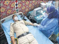  ?? WASEEM ANDRABI/ HT ?? A health worker collects samples from a policeman who recovered from Covid-19 in Srinagar on Wednesday.