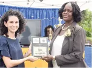  ??  ?? Anna Ward (left), executive director of the C.B. Facey Foundation, presents Nesline Lawrence, principal of Prospect Primary, with the winning trophy. The C.B. Facey Foundation was the main sponsor of the Trees for Peace competitio­n.