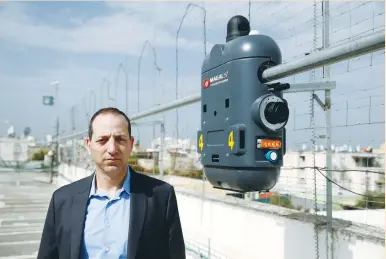  ?? (Baz Ratner/Reuters) ?? MAGAL SECURITY SYSTEMS chief executive Saar Koursh poses near one of the company’s products, RoboGuard, which is a surveillan­ce robot, atop the roof of their offices in Yahud earlier this month. One stock that has already seen a big surge is Magal,...