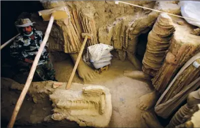  ?? (File Photo/AP/Dusan Vranic,) ?? An Afghan archaeolog­ist stands Oct. 12, 2010, next to remains of Buddha statues discovered inside an ancient temple in Mes Aynak valley, south of Kabul, Afghanista­n.