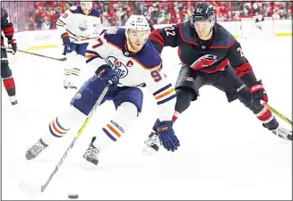  ??  ?? Edmonton Oilers’ Connor McDavid (97) drives the puck around Carolina Hurricanes’ Brett Pesce (22) during thefirst period of an NHL hockey game on Feb 15 in Raleigh, North Carolina. (AP)