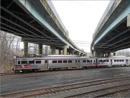  ?? PETE BANNAN – DIGITAL FIRST MEDIA ?? A SEPTA Thorndale-bound train passes underneath Route 202 in East Whiteland and West Whiteland Tuesday. Preliminar­y constructi­on begins this week on a $26.4 million contract to complete the final phase of the U.S. 202 Section 300 improvemen­t project,...