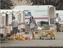  ?? Al Seib Los Angeles Times ?? MAIL CARRIERS load trucks in Van Nuys this month. A judge issued a nationwide preliminar­y injunction sought by 14 states against the U.S. Postal Service.