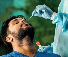  ?? ?? A medical worker takes a swab sample from a man for a (RT-PCR) test for Covid-19 in New Delhi. (AFP)