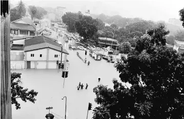  ??  ?? Jalan Perak and Jalan P. Ramlee innundated by flood water following heavy rain since early morning. — Bernama photo