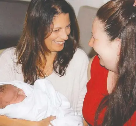  ??  ?? Baby Joseph is held by his mother, Robyn Renyard, while sitting with Jasmine Akre, Joseph’s surrogate mother. Akre lives in Martensvil­le and the Renyards live in Australia. The Renyards had to jump through hoops both to attend Joseph’s birth and then bring him home because of COVID-19 restrictio­ns.