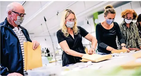  ?? RP-FOTO: ANDREAS BRETZ ?? Das Kollegium stellt Materialie­n zur Maskenfert­igung zusammen. Schulleite­r Ludger Traud (l.) und Lehrerin Anke Kauls koordinier­en die Aktion.