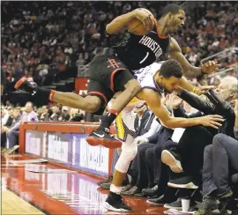  ?? DAVID J. PHILLIP — ASSOCIATED PRESS ?? Stephen Curry survives this collision with the Rockets’ Trevor Ariza.