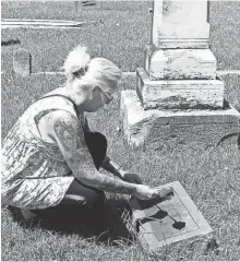  ?? PROVIDED ?? Stacey Humphreys places a rose behind the headstone of Beulah Cawthon in Holly Springs.