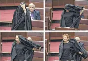  ?? LUKAS COCH / AAP IMAGE VIA AP ?? Sen. Pauline Hanson takes off a burqa she wore Thursday into the Senate chamber at Parliament House in Canberra, Australia. Hanson, leader of the anti-Muslim, anti-immigratio­n One Nation minor party, sat wearing the black head-to-ankle garment for more...