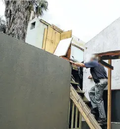  ?? Picture: Simphiwe Nkwali ?? The manager of one of the Sandton properties that was turned into a slum climbs the rickety stairs leading to a shack built on top of a roof.