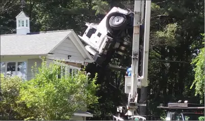  ?? Photo by Joseph Fitzgerald ?? A crane truck tipped over in the yard of this home on Pound Hill Road in North Smithfield. One of the truck’s stabilizin­g outriggers crashed into the home’s family room, just a few feet from where the residents were sitting at the time.