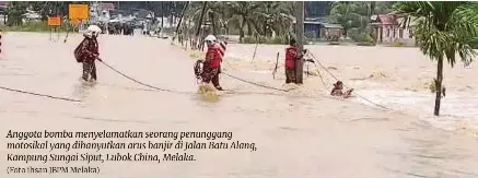  ?? (Foto ihsan JBPM Melaka) ?? Anggota bomba menyelamat­kan seorang penunggang motosikal yang dihanyutka­n arus banjir di Jalan Batu Alang, Kampung Sungai Siput, Lubok China, Melaka.