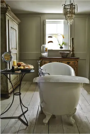  ??  ?? ABOVE Tina created a period- style family bathroom using antique furniture and sanitary ttings found on eBay, such as the double- ended bath that was installed in the centre of the room FACING PAGE The walls of the attic guest bedroom are lined with...