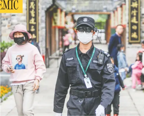  ?? AFP VIA GETTY IMAGES ?? A security officer wears an augmented reality headset to measure a person’s body temperatur­e at a park in Hangzhou, China, last week. The emergence of COVID-19 has been a public-relations disaster for China, an emerging superpower keen to bolster its internatio­nal influence and prestige.