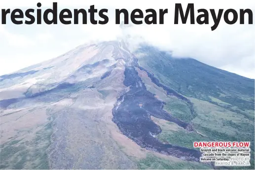 ?? PHOTO BY RHAYDZ B. BARCIA ?? DANGEROUS FLOW Grayish and black volcanic material cascade from the slopes of Mayon Volcano on Saturday.