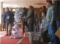  ?? AP ?? A Nepalese election commission officer empties a ballot box prior to counting the votes in Kathmandu, Nepal, on Friday. —