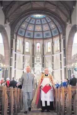  ??  ?? The Prince of Wales is shown around St Patrick’s Church in Belfast by then church administra­tor Fr Michael Sheehan in December 2015