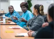  ??  ?? Burton School District’s Grandparen­ts Raising Grandchild­ren group discuss holiday traditions and plan their upcoming Christmas party Wednesday.