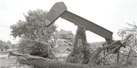  ?? Scott Kingsley photos / Houston Chronicle ?? A pump jack gathers debris, including remnants of Joy Rizzi’s townhome, at the Riverview at Forest Cove complex on Sunday.