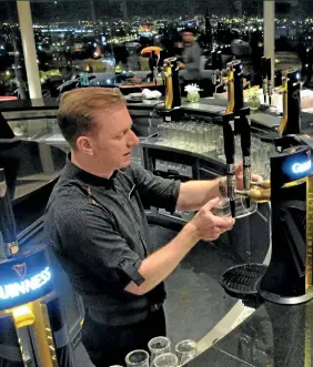  ?? (Shawn Pogatchnik/AP/SIPA) ?? Guinness beer expert Domhnall Marnell pours visitors a pint of stout at the Gravity Bar penthouse layout in Dublin.