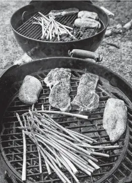  ?? Marvin Pfeiffer / San Antonio Express-News ?? Rib-eye steaks, chicken breasts and asparagus grilled with charcoal that’s infused with onion and garlic is a fun, tasty seasoning option.