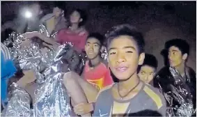  ??  ?? The boys trapped in the caves, above, Below, praying relatives