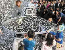  ?? ?? Cox draws on a model spaceship for a live art performanc­e with children from make-a-wish Foundation at Central mtr station in Hong Kong.