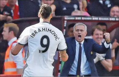  ?? HANNAH MCKAY / REUTERS ?? Manchester United manager Jose Mourinho celebrates Zlatan Ibrahimovi­c scoring the team’s third goal in Sunday’s 3-1 EPL victory over Bournemout­h at Vitality Stadium in Bournemout­h.
