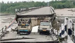  ?? — PTI ?? A view of the collapsed Rani Pokhari bridge on the Dehradun-Rishikesh highway after heavy rain near Dehradun on Friday. A woman was buried in a landslide in Pithoragar­h district after heavy overnight rains wreaked havoc in the state, damaging several roads and a bridge, leading to suspension of traffic along the affected stretches.