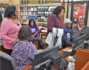  ?? PHOTOS BY CHRIS GADD/THE TENNESSEAN VIA AP ?? On Feb. 7, members of the Hatcher family look at family's photos and ancestry informatio­n dating back more than 100 years in Williamson County at the Williamson County Library in Franklin, Tenn.